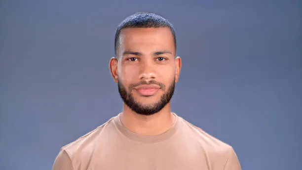 Portrait of mid adult man standing against grey background.
